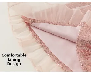 Gros plan détaillé de robe rose pour fille avec paillettes et couches de doublure en satin