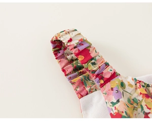 Detail of elastic ruffled shoulder strap on girl floral summer dress with tiny blossoms