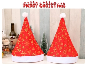 Detailed view of red Christmas hats with gold snowflake patterns and white fur trim