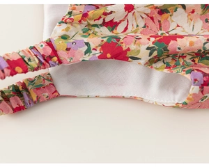 Detail of floral print headband showing cotton fabric texture and elastic stitching