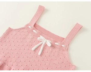Detailed close-up of pink knit camisole featuring pointelle patterns and a white bow