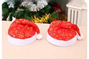 Detail of red Christmas hats with gold snowflake patterns and white plush trim
