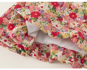 Detail of floral toddler dress showing multi-colored patterns and ruffled white lining