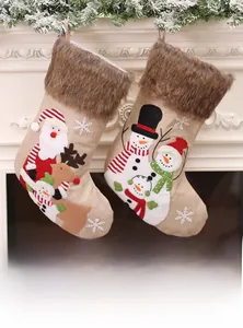 Vue détaillée de chaussettes de Noël en toile de jute avec broderie Père Noël et bonhomme de neige