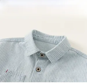 Detail shot of blue and white striped shirt collar with dark grey textured buttons