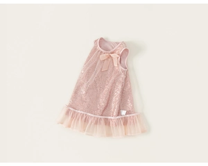 Détail d'une robe rose à paillettes avec nœud en soie et volants en tulle sur l'ourlet