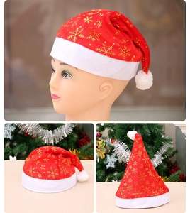 Close-up of red Christmas hat with gold snowflake patterns and white plush trim and ball