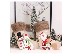 Détail de chaussettes de Noël avec motifs bonhomme de neige et bordure en fausse fourrure