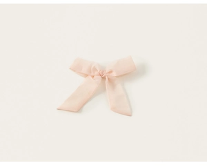 Détail du nœud en tulle rose sur cette robe de princesse d'été sans manches pour fille