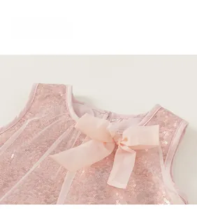 Détail de l'encolure d'une robe rose à paillettes avec nœud mousseline et tulle fin