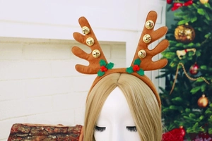 Detail of Christmas reindeer antlers headband with gold bells and festive holly leaves