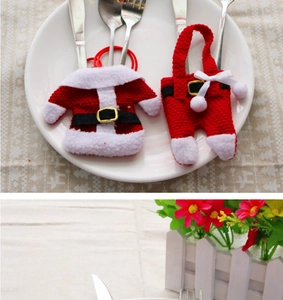 Detail of Christmas cutlery holder set with red Santa suit design and white plush trim