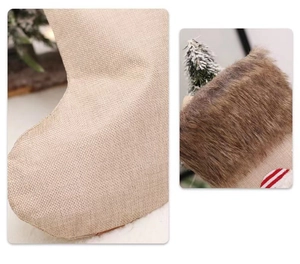 Détail d'une chaussette de Noël en toile avec bordure en fausse fourrure brune et tissu rustique