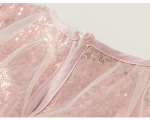 Détail de la robe en tulle rose à paillettes avec ouverture goutte et bouton au dos