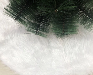 Close-up of white plush Christmas tree skirt with fluffy faux fur texture at the base