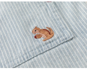 Close-up of fine light blue striped cotton fabric with a detailed chipmunk embroidery