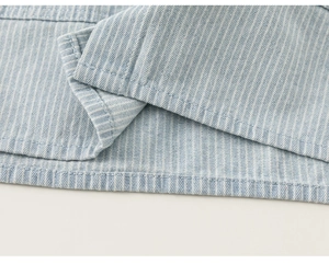Close-up of high-quality light blue striped fabric showing precise hem stitching detail