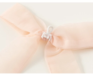 Détail du nœud en mousseline rose avec texture délicate et attache élastique à crochet