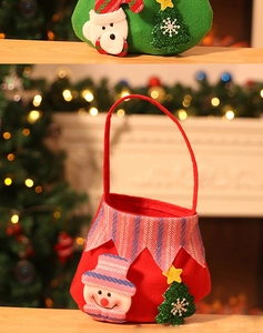 Close-up of felt Christmas gift bags with snowman and bear designs by a fireplace