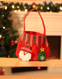 Detail view of a red felt Christmas gift bag featuring a 3D Santa Claus and green tree