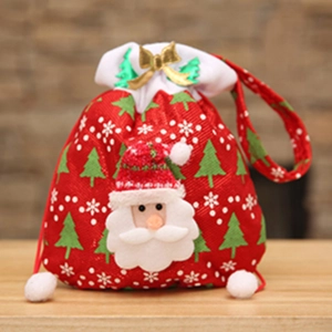 Weihnachtsgeschenkbeutel mit Weihnachtsmann-Patch und Schneeflocken auf Holzoberfläche
