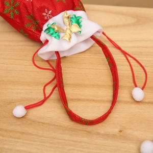 Detail eines weihnachtlichen Geschenkbeutels mit grünen Schneeflocken und Pelzbesatz