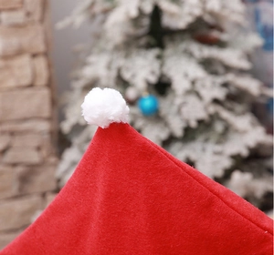 Detail of red Christmas chair cover with white plush pompom and felt texture finish