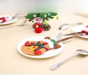 Lebkuchenmann Besteckhalter auf weißem Teller mit weihnachtlicher Tischdeko