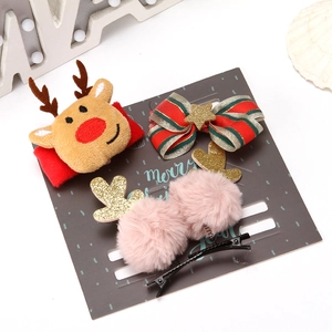 Detail of Christmas hair accessory set with reindeer antlers and festive bow on display card