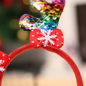 Détail macro du serre-tête de Noël avec bois de renne en paillettes arc-en-ciel et flocon