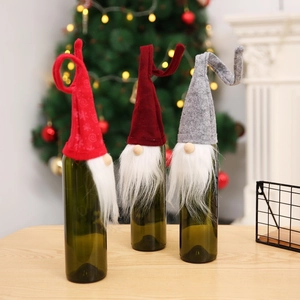 Close-up of gnome Christmas wine bottle covers with plush beards and knitted hats