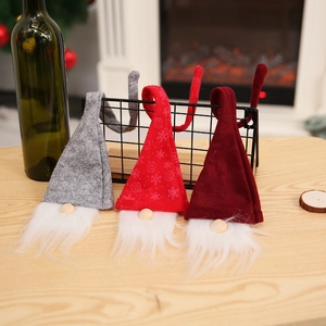 Close-up of three handmade Christmas gnome wine bottle covers with bendable felt hats