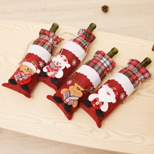 Close-up of four festive Christmas wine bottle covers with Santa and reindeer on wood table