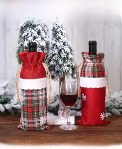 Close-up of burlap Christmas wine bottle covers with red plaid accents and snowflake appliques