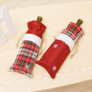 Close-up of burlap Christmas wine bottle bags with snowflake patterns and red green plaid