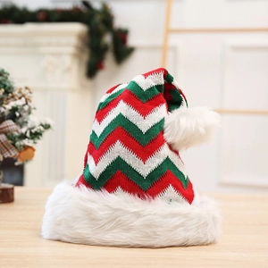 Detail of red and green chevron knit Christmas hat with soft white plush pom-pom and brim