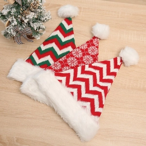 Three-piece knitted Christmas hats set with striped and snowflake patterns on wood