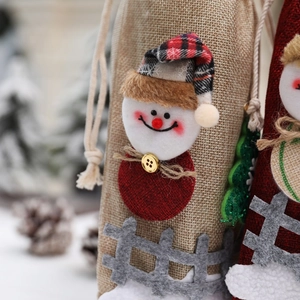 Detail of Christmas snowman wine bottle cover made of burlap with festive 3D decorations