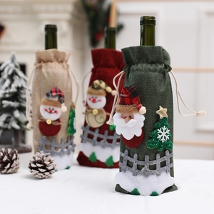 Detailed close-up of burlap Christmas wine bottle covers with Santa and Snowman patches