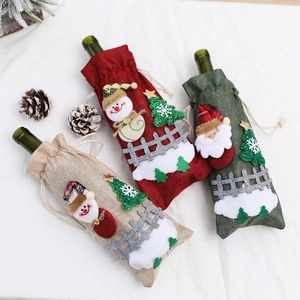 Detailed view of linen Christmas wine bottle covers with Santa and snowman embroidery