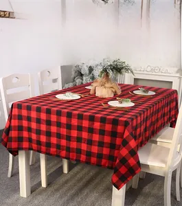 Detail of red and black buffalo plaid Christmas tablecloth in a cozy holiday dining setting