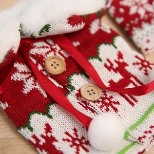 Close-up of knitted Christmas wine bottle cover with elk pattern and plush ball detail