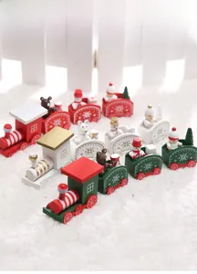 Détail du petit train de Noël en bois avec figurines sur tapis en peluche blanche
