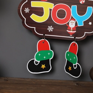 Detail of wooden Christmas Joy hanging sign with Santa Claus and festive boots