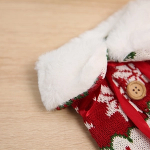 Detail of knitted Christmas wine bottle cover with faux fur collar and snowflake pattern