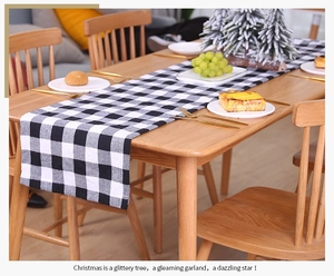 Gros plan d'un chemin de table à carreaux noirs et blancs sur une table à manger en bois