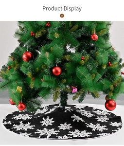 Detail of plush black Christmas tree skirt with white embroidered snowflake pattern