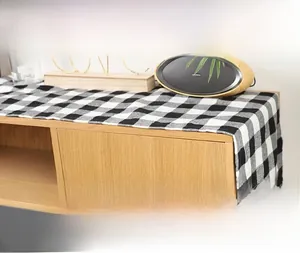 Gros plan du chemin de table à carreaux noirs et blancs avec texture tissée sur un meuble