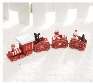 Petit train de Noël en bois rouge avec figurines festives sur tapis blanc pelucheux