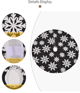 Detail of black plush Christmas tree skirt with white snowflake and hook loop fastener